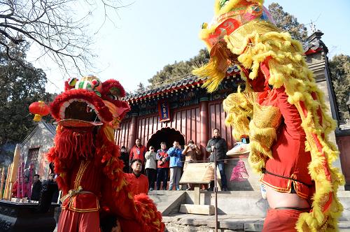 2月2日,游客在八大處文昌殿舉行的大法會(huì)上觀看舞獅表演。新華社記者 李俊東 攝