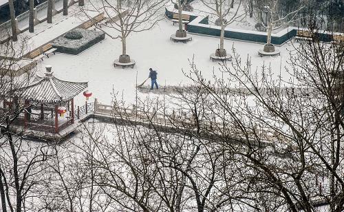 2月7日,北京市朝陽區(qū)的一個(gè)街心公園,工作人員冒雪給行人清掃出一條道路。新華社記者 張宇 攝