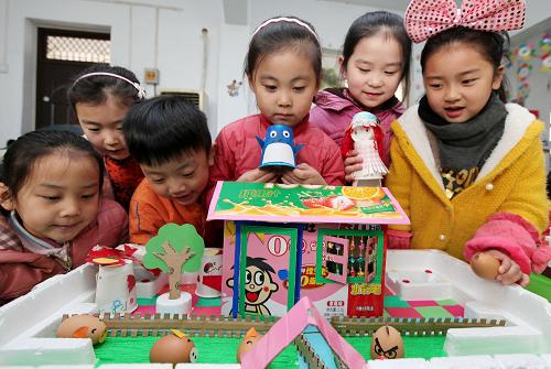 2月26日,山東省棗莊市君山路小學(xué)幼兒園的孩子在觀看老師制作的“環(huán)保玩具”。新華社發(fā)(孫中喆 攝)
