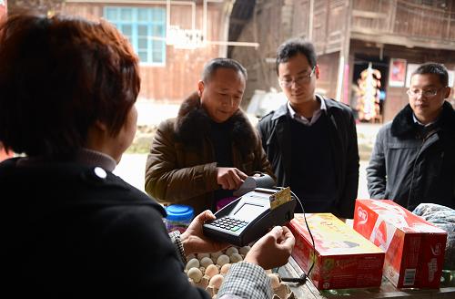 2月26日,在湖北省宣恩縣慶陽壩村,村民在有金融服務(wù)功能的“小賣部”刷卡取款。眼下正值春耕大忙時(shí)節(jié),湖北省宣恩縣大多數(shù)村民今年可以就近在“小賣部”辦理跨行轉(zhuǎn)賬、現(xiàn)金支取、在線支付等金融業(yè)務(wù),并且無需支付手續(xù)費(fèi)用。“家門口的銀行”解決了農(nóng)民以前存取款需進(jìn)城辦理的煩惱,為春耕生產(chǎn)贏得寶貴時(shí)間。自去年以來,宣恩縣以遍布鄉(xiāng)村的“小賣部”為依托,由銀行和商戶合作設(shè)立村級惠農(nóng)金融服務(wù)聯(lián)系點(diǎn)1068個(gè)。村民可在“聯(lián)系點(diǎn)”辦理惠農(nóng)補(bǔ)貼、社保資金、項(xiàng)目補(bǔ)償、電費(fèi)支付等領(lǐng)取和支付業(yè)務(wù)。新華社發(fā)(宋文 攝)