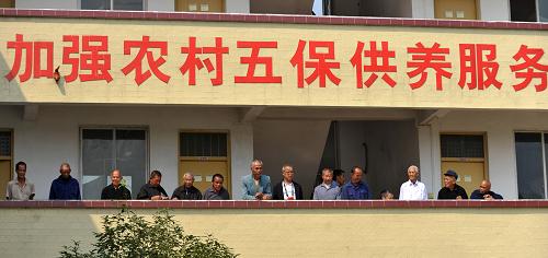 在廣西賀州市鐘山縣清塘鎮(zhèn)敬老院,幾名老人在走廊上聊天曬太陽(2013年10月26日攝)。國務(wù)院近期印發(fā)《關(guān)于建立統(tǒng)一的城鄉(xiāng)居民基本養(yǎng)老保險制度的意見》,決定將現(xiàn)行新型農(nóng)村社會養(yǎng)老保險制度與城鎮(zhèn)居民社會養(yǎng)老保險制度合并實施,建立全國統(tǒng)一的城鄉(xiāng)居民基本養(yǎng)老保險制度。2009年和2011年,我國先后啟動實施新農(nóng)保和城居保試點,并于2012年在全國所有地區(qū)推行。截至2013年底,全國參加新農(nóng)保和城居保的總?cè)藬?shù)達到4.98億人(其中城鎮(zhèn)居民2399萬人),其中按月領(lǐng)取養(yǎng)老待遇的城鄉(xiāng)老年居民1.38億人(其中城鎮(zhèn)老年居民近1000萬人)。新華社記者 陸波岸 攝