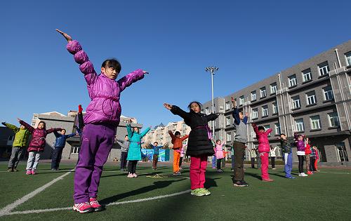 2月27日,北京市東城區(qū)西總部小學的學生們在操場上做操。 新華社發(fā)(周良 攝)