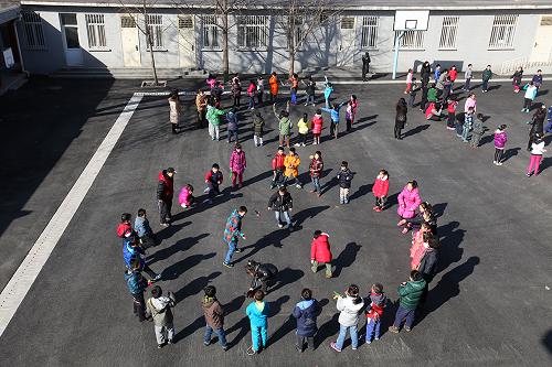 2月27日,北京市東城區(qū)西總部小學的學生們在操場上做游戲。新華社發(fā)(周良 攝)