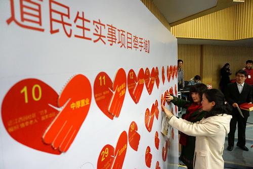2月27日,愛心企業(yè)代表在民生實(shí)事項(xiàng)目牽手墻上進(jìn)行“握手”認(rèn)領(lǐng)。新華社發(fā)(吳煌 攝)