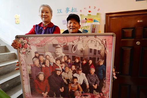 2月27日,兩位居民展示自己所住單元的“全家福”。從2013年9月以來,甘肅省酒泉市肅州區(qū)北新街社區(qū)嘗試在轄區(qū)21棟廉租房的部分單元內(nèi)開展“單元一家親”活動(dòng)。在社區(qū)工作人員的指導(dǎo)和幫助下,廉租房小區(qū)的居民結(jié)合自己所住的單元特點(diǎn),分別創(chuàng)建起文明之家、光榮之家、互助之家等10個(gè)特色主題單元,居民們通過公選樓院長、開辟議事欄、設(shè)計(jì)樓道文化墻,安排衛(wèi)生值日表和張貼住戶“全家福”合影照等方式加強(qiáng)溝通交流,將所居住的單元打造成一個(gè)充滿創(chuàng)意和溫馨的大家庭,不僅美化了樓道環(huán)境,也增強(qiáng)了居民的歸屬感、認(rèn)同感和凝聚力。新華社記者 陳斌 攝