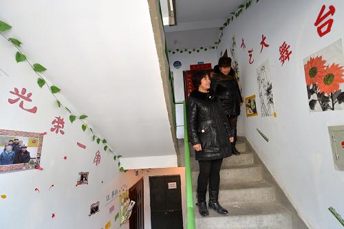 2月27日,兩位居民在觀看樓道內(nèi)的才藝展示墻。新華社記者 陳斌 攝