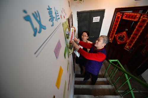 2月27日,北新街社區(qū)副主任張玉蓮(左)和居民一起整理樓道內(nèi)的愛心服務(wù)袋。新華社記者 陳斌 攝