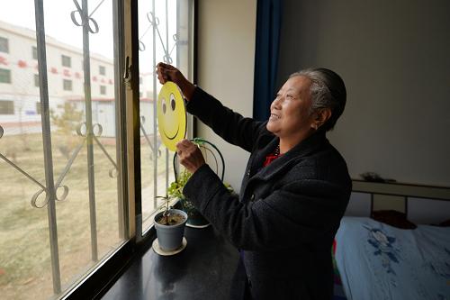 2月27日,廉租房小區(qū)“光榮之家”單元居民崔桂芳在自己家里懸掛代表鄰里互助的笑臉標(biāo)志。新華社記者 陳斌 攝