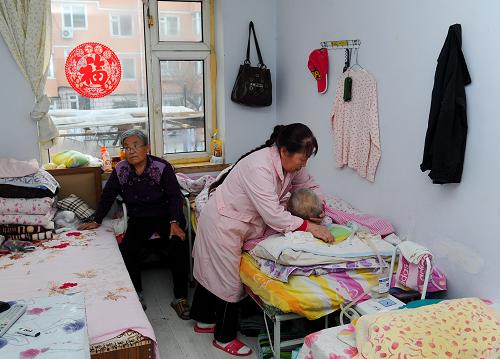長(zhǎng)春市華成老年護(hù)理院內(nèi)的護(hù)工在照顧老人(1月16日攝)。新華社記者 許暢 攝