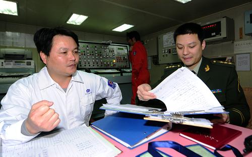 3月28日,“盛池號”船長邱永先配合大連邊防檢查站工作人員辦理通關(guān)手續(xù)。 運輸中國援日2萬噸燃油的“盛池”號油輪3月28日下午停靠進大連石化港深水碼頭,開始裝油,大連邊防檢查站已經(jīng)為油輪辦好了快速通關(guān)手續(xù),“盛池號”預(yù)計29日起航駛往日本。按照日方要求,這2萬噸燃油將分別運往日本兩個城市,其中1萬噸汽油運往廣島縣江田島市,1萬噸柴油運往愛媛縣今治市。 新華社記者任勇攝