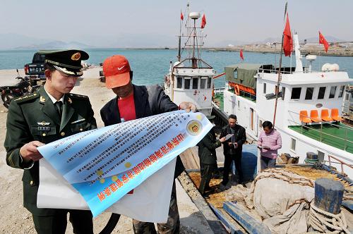 4月26日,青島鰲山邊防派出所警官在轄區(qū)碼頭組織漁船民學(xué)習(xí)新《條例》。5月1日起,山東省將開始實施《山東省沿海船舶邊防治安管理條例》,對一些涉及沿海船舶違規(guī)違法行為作出了更詳細(xì)的處罰規(guī)定。今后出海船舶、出海生產(chǎn)作業(yè)人員未按照規(guī)定攜帶出海邊防證件的,將最高處以1000元罰款;出海船舶未按照規(guī)定編刷船名、船號或者船名、船號模糊不清出海的,將最高罰款5000元。新華社記者 李紫恒 攝