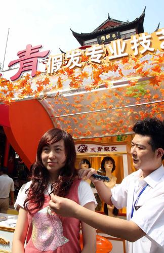 9月7日,老字號(hào)永青假發(fā)店的工作人員用假發(fā)為游客打造全新造型。新華社記者 劉穎 攝
