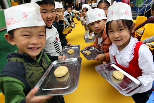 9月7日,運城市新加陽光幼兒園的小朋友展示他們制作的月餅。新華社發(fā)(薛俊 攝)