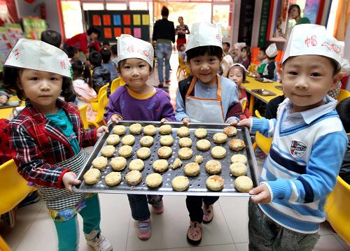 9月7日,運城市新加陽光幼兒園的小朋友展示他們制作的月餅。新華社發(fā)(薛俊 攝)