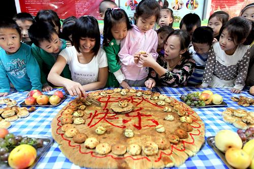 9月7日,運城市新加陽光幼兒園的小朋友和老師一起品嘗月餅。新華社發(fā)(薛俊 攝)