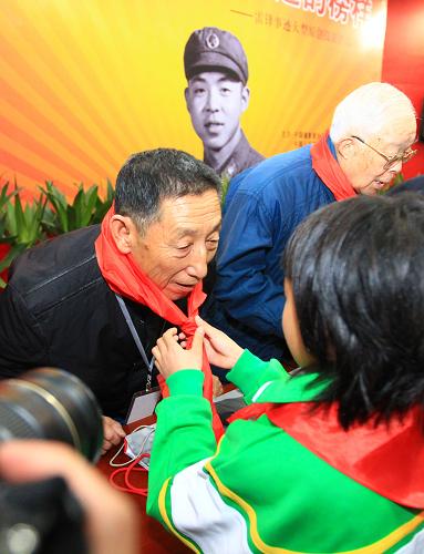 3月2日,在開(kāi)幕式上少先隊(duì)員為老攝影家季增(左)佩戴紅領(lǐng)巾。新華社記者 查春明 攝