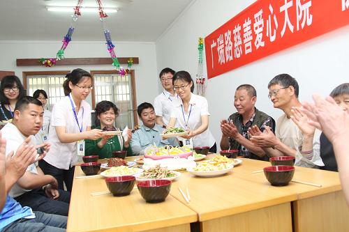 5月17日,無錫廣瑞路街道廣豐社區(qū)的慈善愛心大院工作人員給殘疾人送上自己燒制的菜肴。新華社發(fā)(盛國平 攝)