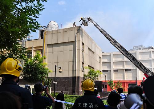 8月25日,消防人員模擬解救因火災(zāi)困于樓頂?shù)木用瘛P氯A社記者 張超群 攝