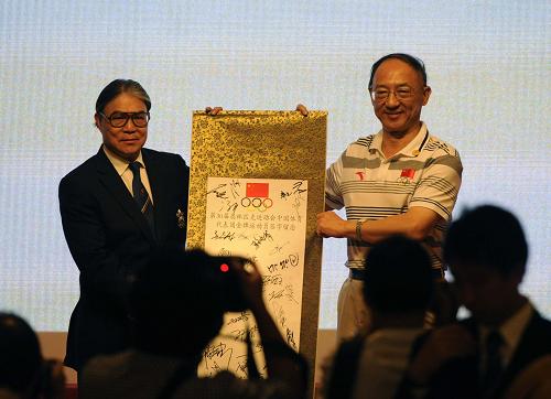 8月25日,國(guó)家體育總局局長(zhǎng)劉鵬(右)向中國(guó)香港奧委會(huì)主席霍震霆贈(zèng)送有全體金牌運(yùn)動(dòng)員簽名的字畫(huà)。新華社記者 趙宇思 攝