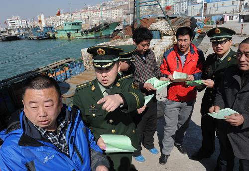 3月14日,青島沙子口邊防派出所民警在轄區(qū)碼頭對(duì)漁民開展法制宣傳教育。新華社記者 李紫恒 攝
