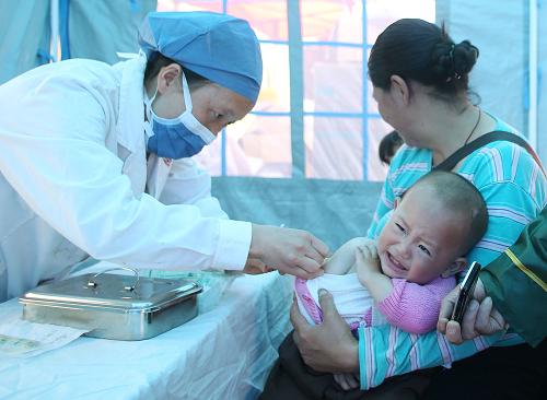 5月6日,在位于老蘆山中學內的臨時接種點,1歲3個月的男孩付彥珺在接種麻腮風疫苗。當天,蘆山地震災區(qū)啟動全災區(qū)兒童免費接種疫苗工作,計劃從5月6日到12日,在蘆山縣、寶興縣、雨城區(qū)、天全縣受災群眾集中安置地設置92個接種點,對18月齡至14歲的兒童,免費接種1劑次甲肝滅活疫苗,對8月齡至14歲的兒童,免費接種1劑次麻腮風減毒活疫苗,以預防災區(qū)甲型肝炎、麻疹、風疹、流行性腮腺炎的暴發(fā)或流行。新華社記者 王申 攝