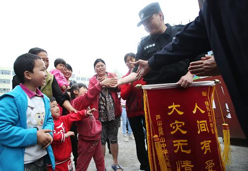 5月6日,在老蘆山中學(xué)受災(zāi)群眾安置點,孩子們和來自綿陽的警察叔叔握手告別。新華社記者 王申 攝