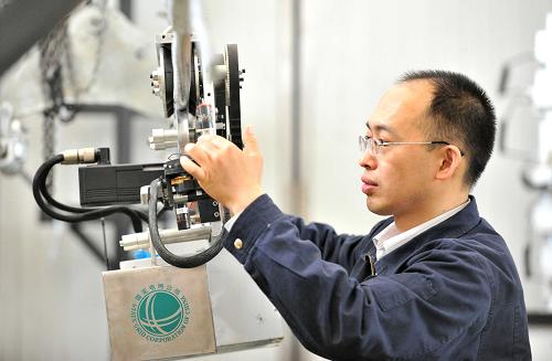 5月6日,郭銳在調(diào)試一臺(tái)高壓輸電線檢測(cè)機(jī)器人。新華社記者 朱崢 攝