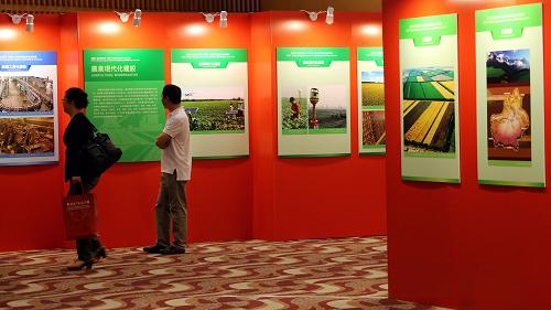 5月8日,兩位觀眾在香港會展中心參觀新疆生產(chǎn)建設(shè)兵團(tuán)香港招商引資宣傳活動圖片展。 新華社記者 李鵬 攝