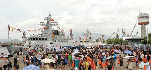 7月1日,市民排隊(duì)等候參觀新型護(hù)衛(wèi)艦“欽州艦”(左)和“惠州艦”(右)。 當(dāng)日是香港回歸祖國(guó)16周年紀(jì)念日,中國(guó)人民解放軍駐香港部隊(duì)對(duì)外開放海軍基地昂船洲軍營(yíng),逾1.3萬香港市民入營(yíng)參觀。自進(jìn)駐香港以來,駐軍每年都舉辦“軍營(yíng)開放日”活動(dòng),包括此次活動(dòng)在內(nèi),已有約52萬人次香港市民入營(yíng)參觀。 新華社記者 黃本強(qiáng) 攝