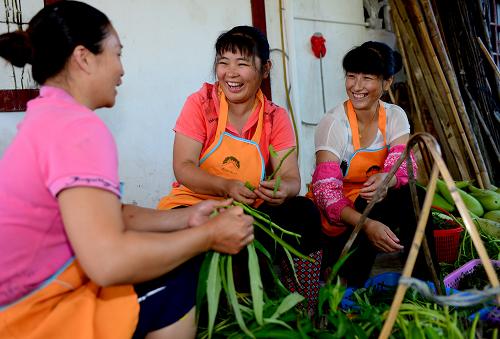 8月7日,古田鎮(zhèn)青年農(nóng)民賴淑芳在新建的游客購(gòu)物街商鋪前迎候顧客。新華社記者 張國(guó)俊 攝