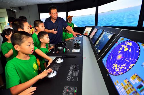 8月7日,在天津海運職業(yè)學院的仿真航海模擬器訓練中心,學生們在教師的指導下體驗船舶駕駛艙模擬環(huán)境。 當日,2013年“少年派的職業(yè)技能體驗之旅”夏令營開營,30名參加夏令營的天津中小學生將在天津海河教育園區(qū)的職業(yè)院校校園參觀現(xiàn)代圖書館、生產(chǎn)實訓場地、3D打印機等,并體驗消防公安工作、學習安全保護知識,了解職業(yè)教育。 新華社發(fā)(游思行 攝)