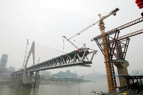 這是建設(shè)中的的重慶千廝門嘉陵江大橋(9月23日攝)。目前,橫跨嘉陵江的被稱為“重慶雙子大橋”之一的重慶千廝門大橋正在加緊建設(shè)中,整座大橋的12組共24根斜拉索已經(jīng)完成掛索,大橋?qū)⒂?0月底合龍。千廝門嘉陵江大橋和東水門長(zhǎng)江大橋被稱為“重慶雙子大橋”,兩橋之間用隧道相連,連接重慶主城解放碑、江北城、彈子石三地交通。新華社發(fā)(趙俊超 攝)