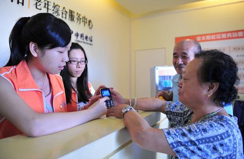 9月24日,福州市倉(cāng)山區(qū)的69歲老人歐淑香(右一)和74歲的老伴林后重來(lái)到福州市一家老年人綜合服務(wù)中心領(lǐng)取免費(fèi)的應(yīng)急救助手機(jī),該手機(jī)能讓老人享受24小時(shí)的居家助老應(yīng)急救助服務(wù)。新華社記者 魏培全 攝