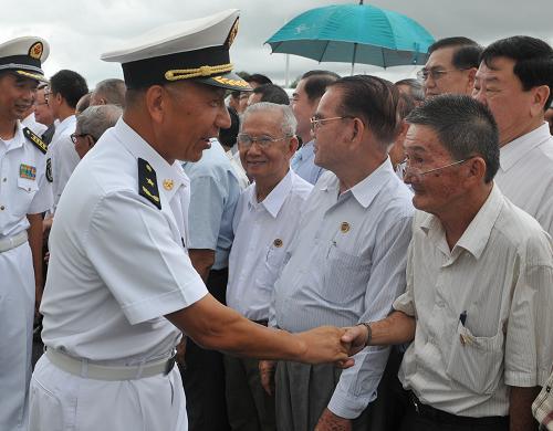 9月24日,在柬埔寨西哈努克港,中國海軍和平方舟醫(yī)院船指揮員沈浩少將(前)與華人華僑代表握手。新華社記者 李弘 攝