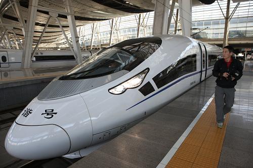 9月25日,一名記者走過CRH380CL新型高速動車組。由中國北車長客股份公司研制的CRH380CL新型動車組投入京滬高鐵運營。新型動車組實現(xiàn)了較大的車頭創(chuàng)新,采用了細長比更大的流線型鋁合金車頭,比目前運營的CRH380BL型動車組的車頭長2.6米,使車頭降低了12%的空氣阻力。持續(xù)運行時速為350公里,最高運營時速380公里。CRH380CL新型動車組整列車擁有16節(jié)車廂,定員1053人。9月25日,已經(jīng)有3列CRH380CL型高速動車組投入京滬高鐵運營。新華社發(fā)(劉長龍 攝)