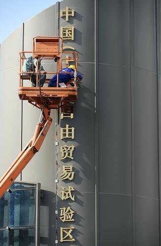 9月26日,工人在安裝“中國(上海)自由貿(mào)易試驗區(qū)”字牌。新華社發(fā)(賴鑫琳 攝)