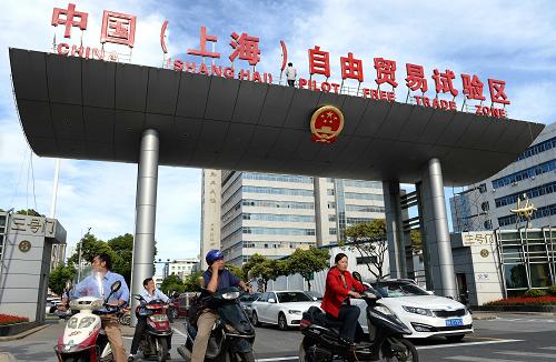 9月26日,人們從上海外高橋保稅區(qū)三號門的“中國(上海)自由貿(mào)易試驗區(qū)”字牌下經(jīng)過。上海市第十四屆人大常委會第八次會議26日通過《關(guān)于在中國(上海)自由貿(mào)易試驗區(qū)暫時調(diào)整實施本市有關(guān)地方性法規(guī)規(guī)定的決定》,依法推進(jìn)中國(上海)自由貿(mào)易試驗區(qū)建設(shè)。決定自10月1日起施行。 新華社發(fā)(賴鑫琳 攝)