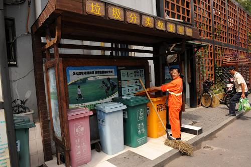 9月24日,上城區(qū)湖濱街道東平巷社區(qū)衛(wèi)生清潔員在整理社區(qū)垃圾分類收集箱。新華社記者 何俊昌 攝