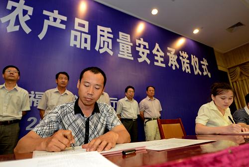 9月27日,福建旺豐生態(tài)農(nóng)業(yè)發(fā)展有限公司負責(zé)人(左前)在福建省第二次產(chǎn)品質(zhì)量安全承諾儀式上簽承諾書。新華社記者 張國俊 攝
