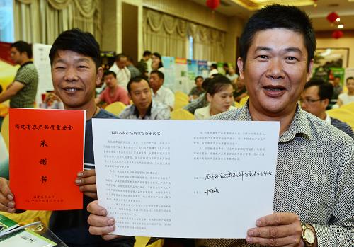 9月27日,廈門鑫毓祥畜禽專業(yè)合作社理事長葉振宏(右)在福建省第二次產(chǎn)品質(zhì)量安全承諾儀式上展示承諾書。當(dāng)日,福建省農(nóng)業(yè)廳舉辦第二次全省農(nóng)產(chǎn)質(zhì)量安全承諾活動,50家農(nóng)產(chǎn)品生產(chǎn)企業(yè)公開向社會承諾確保農(nóng)產(chǎn)品質(zhì)量安全。福建省將通過2至3年的努力,把全省蔬菜、水果、茶葉、食用菌、生豬、家禽六大產(chǎn)業(yè)的主要產(chǎn)品生產(chǎn)納入承諾制管理,通過規(guī)范和完善農(nóng)產(chǎn)品質(zhì)量安全承諾制、“黑名單”制、可追溯制等,形成優(yōu)勝劣汰的良性競爭環(huán)境。新華社記者 張國俊 攝