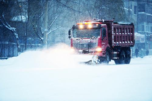 11月18日晨,清雪車輛在一條主干道上清掃積雪。(新華社記者 王凱 攝)