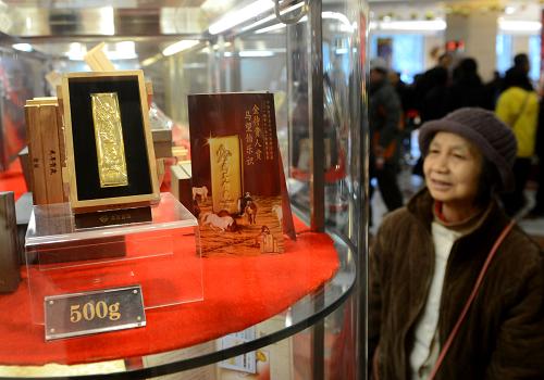 11月19日,消費(fèi)者在菜百商場(chǎng)觀看馬年賀歲金條。(新華社發(fā))