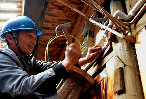 11月19日,湖北省宣恩縣供電公司工作人員在慶陽壩村的吊腳樓里為農(nóng)戶改造供電線路。國家電網(wǎng)湖北恩施土家族苗族自治州宣恩縣供電公司在農(nóng)村實(shí)施“供電延伸服務(wù)”,將供電服務(wù)內(nèi)容由農(nóng)戶戶外延伸到戶內(nèi),既對(duì)農(nóng)戶供電負(fù)責(zé),還對(duì)農(nóng)戶屋內(nèi)的供電線路和用電設(shè)施進(jìn)行日常管理維護(hù)和管理,確保農(nóng)民用上“放心電”。新華社發(fā)(宋文 攝)