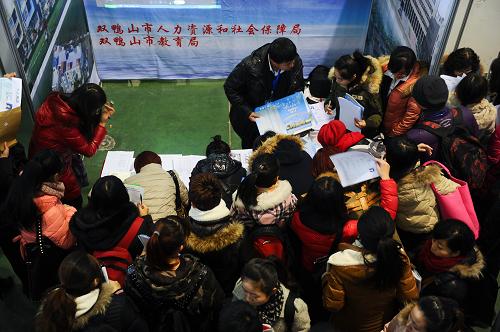 11月30日,求職者在一家用人單位展臺前遞交簡歷。新華社記者 許暢 攝