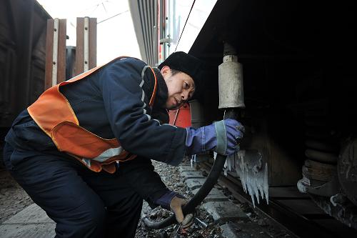 1月13日,太原火車站上水工秦曉寧把水管插進(jìn)注水口,為進(jìn)站的列車上水。新華社記者 詹彥 攝
