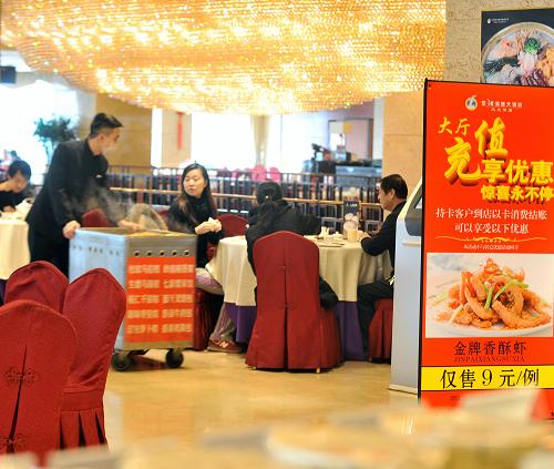 1月10日,太原市民在一家高檔餐廳用餐,餐廳里打出了特價菜促銷廣告。新華社記者 燕雁 攝