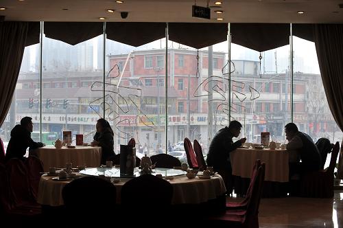 1月10日,太原市民在一家高檔餐廳用餐。這家餐廳窗戶玻璃上打出“宵夜”字樣以招徠夜間客流。新華社記者 燕雁 攝