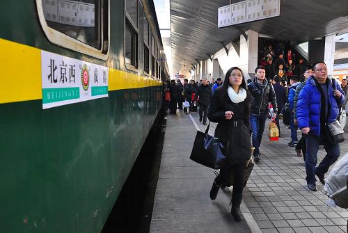 1月13日,旅客在成都火車站準(zhǔn)備登上臨客L34次列車。 當(dāng)日,成都鐵路局2014年春運(yùn)首趟臨客L34次列車從成都火車站開出,列車途經(jīng)廣元、漢中、襄陽、新鄉(xiāng)、石家莊等車站到達(dá)北京西站,運(yùn)行時(shí)間39小時(shí)50分。據(jù)悉,為緩解今年的春運(yùn)壓力,成都鐵路局將根據(jù)需要增開臨客列車。新華社發(fā)(胡志強(qiáng) 攝)