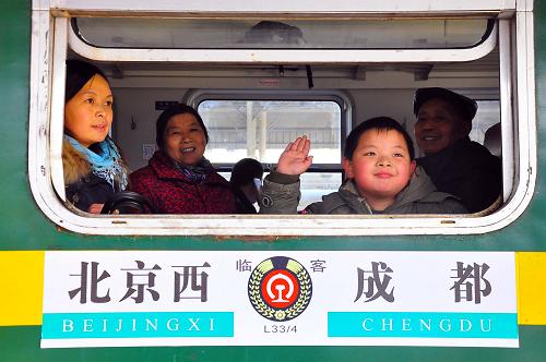 1月13日,一名小朋友在即將發(fā)車的臨客L34次列車上向送行親人道別。 新華社發(fā)(胡志強(qiáng) 攝)