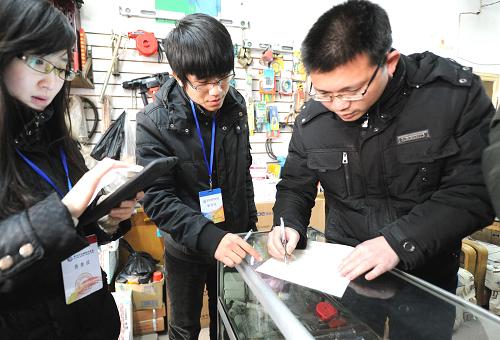 1月15日,一名個(gè)體戶(右)積極配合工作人員填表做好普查工作。新華社記者 李曉果 攝